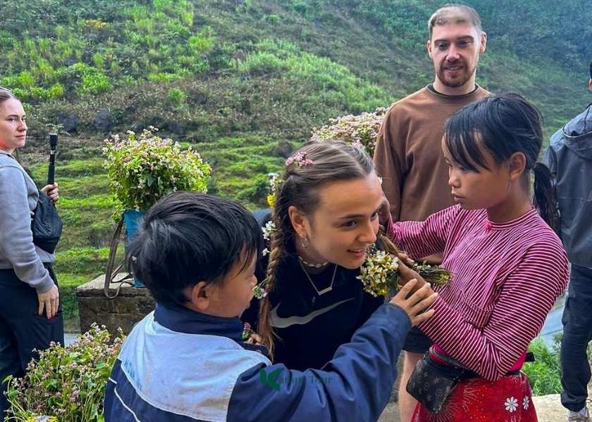 Bambini che intrecciano i capelli ai turisti al passo di Tham Ma a Ha Giang