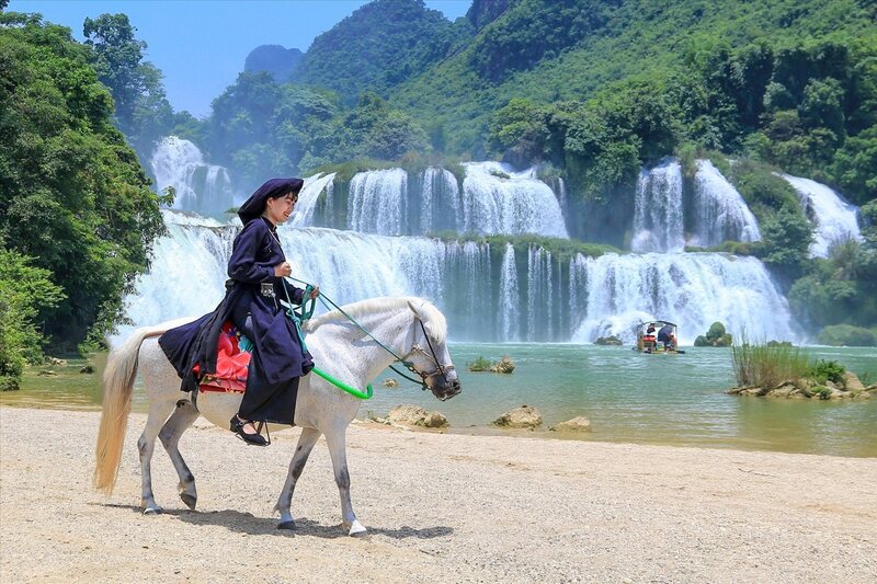 Tay ethnic woman riding a horse at Ban Gioc Waterfall