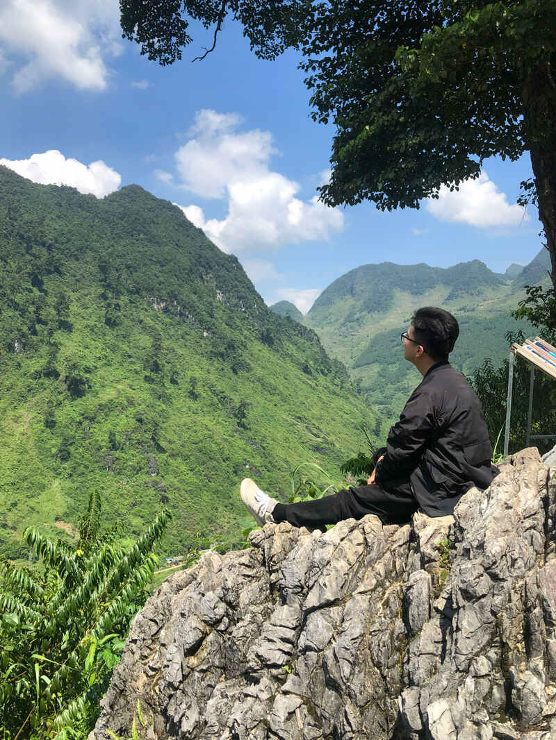 Seduto su una roccia sotto il punto panoramico dell'Albero Solitario nel Ha Giang Loop