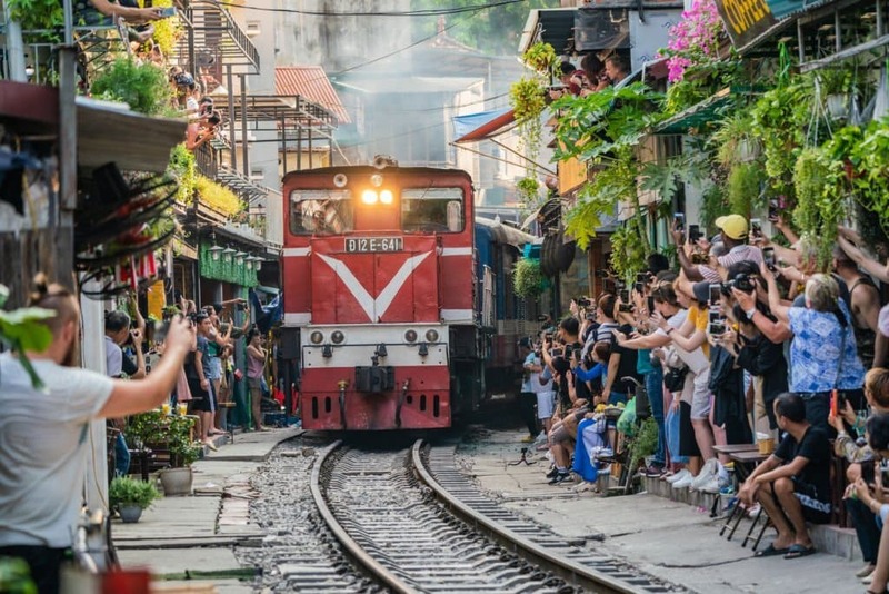 I treni attraversano strade molto strette nella strada del treno di Hanoi