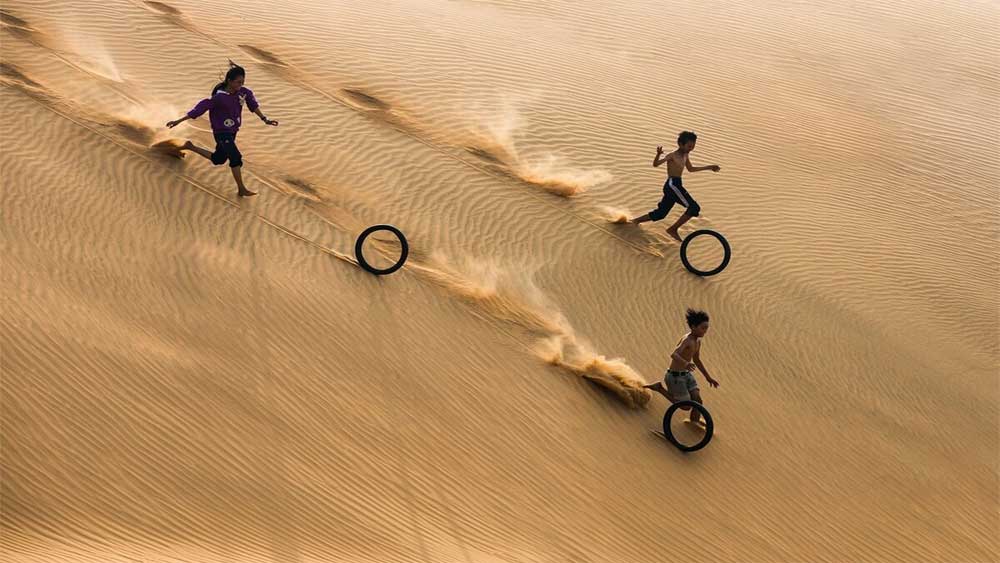 Bambini si divertono sulle dune di sabbia