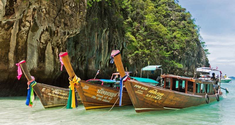 Barche longtail ancorate nelle acque cristalline delle isole Phi Phi, un paradiso tropicale vicino a Phuket.